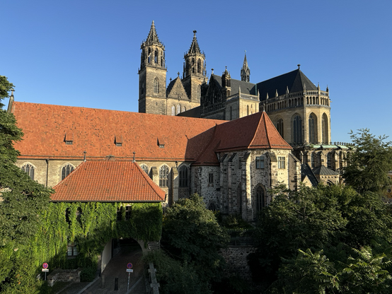 Magdeburger Dom von Osten, vor blauem Himmel, im Vordergrund, das große rote Dach des Remters